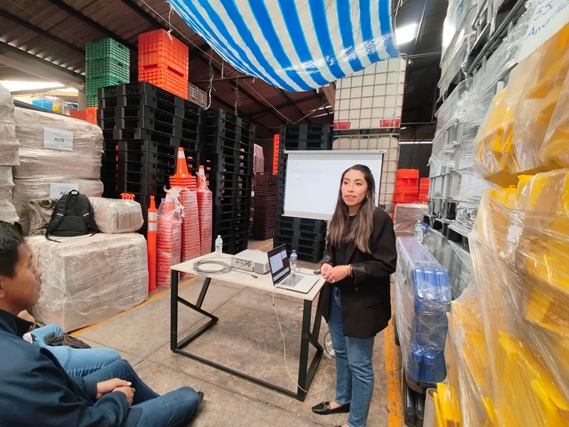 Sandy dando la ponencia en la planta, junto a la pantalla de proyección